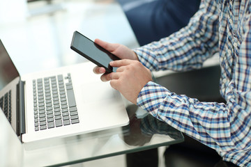 Fototapeta premium close up.business man with a smartphone sitting at his Desk