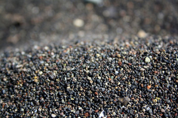 Black sand beach macro photography. Volcanic sand of Santorini Island, Greece.