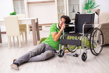 Young handsome man in wheelchair at home