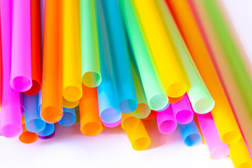 Colored plastic drinking straws on a white background