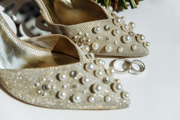 Closeup photo of stylish shoes and luxurious wedding rings