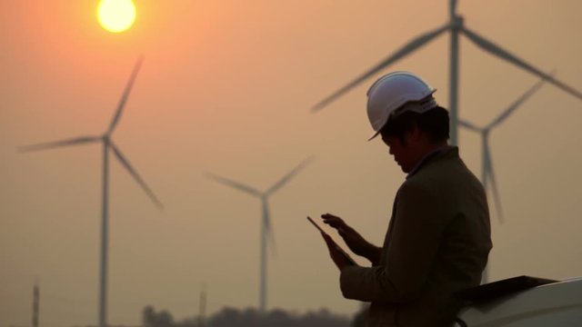 Asian engineers are checking the wind turbine system with a tablet footage 4K