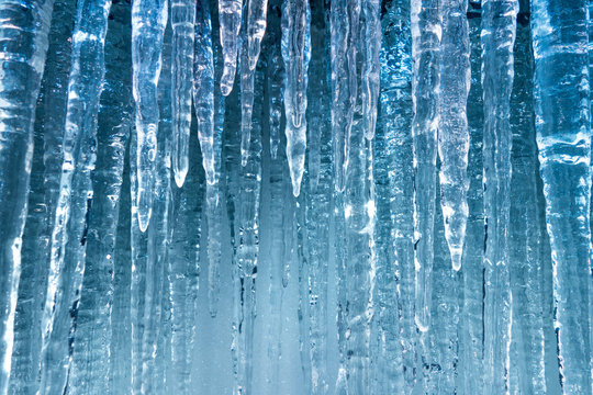pure clear blue hanging ice sickles in winter cold background