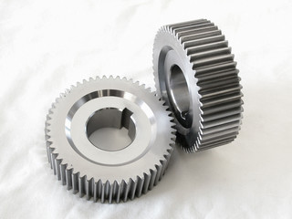 two industrial steel machine gears on a white cloth