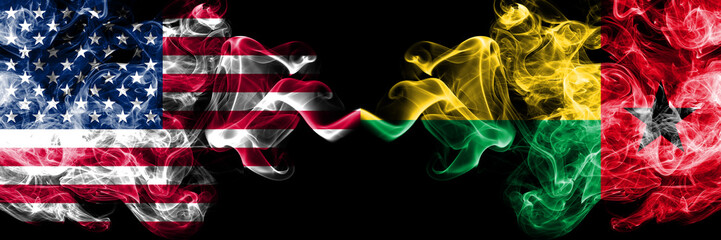 United States of America vs Guinea Bissau smoky mystic flags placed side by side. Thick colored silky smoke flags of America and Guinea Bissau