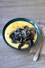 Fried mushrooms and polenta with cheese and chicory. Selective focus.