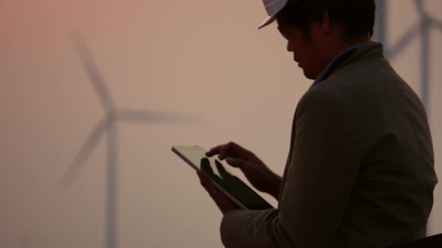 Senior Engineer, Asian are monitoring system wind turbine electricity generation with teblet footage 4K