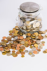 EURO coins spilling out of glass jar