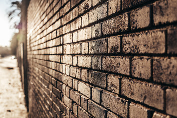 Brick wall background at sunset with sun rays, stone texture.