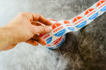 Man hand holding supporter stickers of american elections