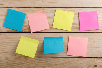 Many colorful sticky note on wooden desk. Copy space