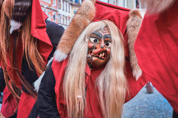 Funny witch with red hood and wart on the nose. Street Carnival in Southern Germany - Black Forest.