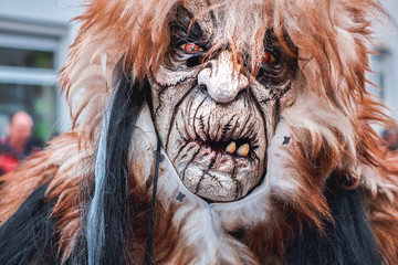 Carnival monster with crooked mouth and bad teeth. Street Carnival in Southern Germany - Black Forest.