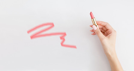 Lipstick in woman's hands on white background. Make up. Open space. 