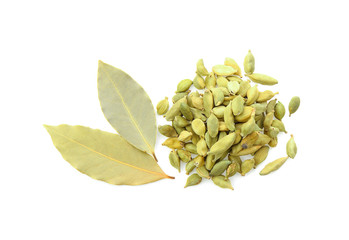 Green cardamom and bay leaves on white background