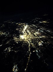 Flying at night over cities below