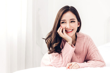Portrait of happy smile asia woman enjoy and relax on the bed in bedroom at home.asian beauty © Art_Photo