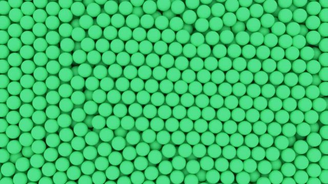 Animated bottom view and flying over pile of a lot of light green ping pong or table tennis balls lying in large container or as if moving on conveyor belt.
