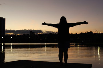 Fototapeta premium silhouette of young woman doing yoga at sunset