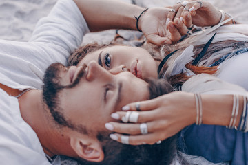 beautiful young couple lying on sand on the beach. love and relationships concept