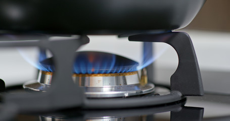 Stove top burner igniting into a blue for cooking