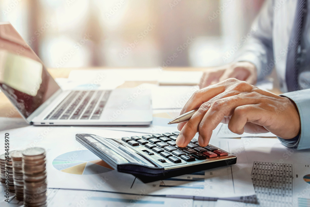 Aufkleber businessman working on desk with using calculator for calculate finance and accounting in office