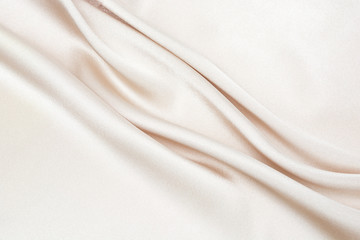 Fototapeta premium The texture of the satin fabric of beige color for the background 