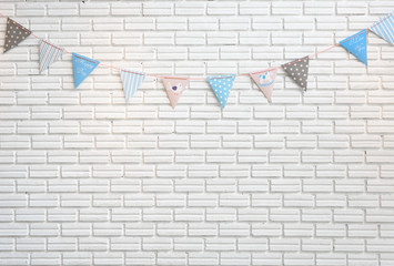 White brick wall decorated by colorful cartoon flag for children