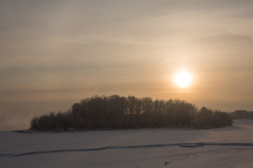 winter frosty sunset on the river in Siberia in winter