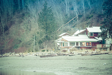 A small cottage nestled between the Pacific Ocean and a forest of evergreens.