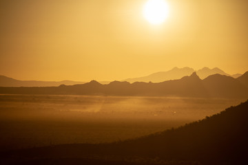 The sun rising over the mountains of the Arizona desert with natural warm hues.