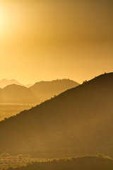 The sun rising over the mountains of the Arizona desert with natural warm hues.