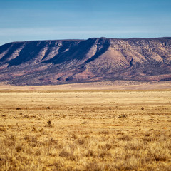 Fototapeta na wymiar A mesa rising up in the distance across a vast desert valley in Arizona.