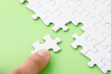 Obraz premium ジグソーパズル White jigsaw puzzle on green background
