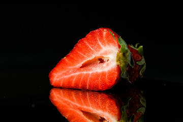 cut strawberries on dark background