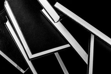 Books piled on top of each other, black and white photography.