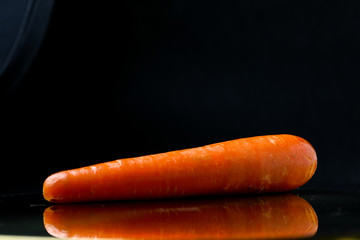 cut fresh carrot on a black background