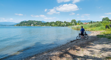 Fototapeta na wymiar Big European lake. Lake Maggiore at Ispra and man with bike, Italy