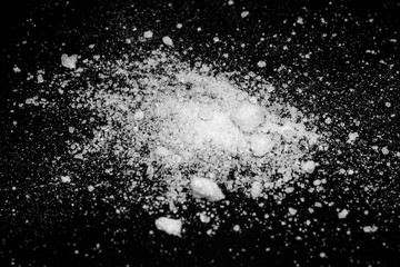 white crystalline powder on a black background. sugar dust 