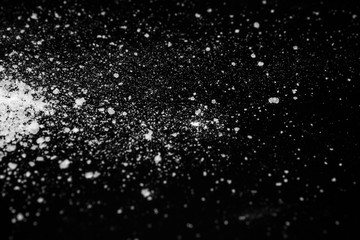 white crystalline powder on a black background. sugar dust 