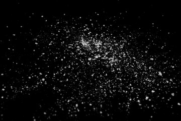 white crystalline powder on a black background. sugar dust 
