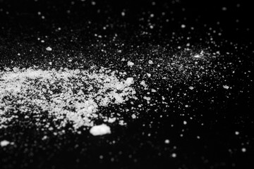 white crystalline powder on a black background. sugar dust 