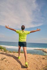 Sportsman on a tropical exotic cliff near the ocean.