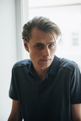 A man in a blue polo poses for menswear advertising. Shooting for men's clothing store