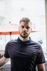 A man in a purple polo and posing for advertising men's clothing. Shooting for men's clothing store