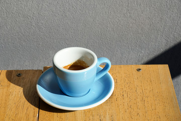 Espresso coffee  in blue ceramic cup on wooden table background.
