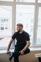 A man in a purple polo and posing for advertising men's clothing. Shooting for men's clothing store