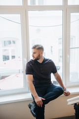 A man in a purple polo and posing for advertising men's clothing. Shooting for men's clothing store