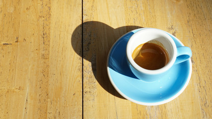 Espresso coffee  in blue ceramic cup on wooden table background.