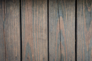 Thick vintage vertical wood planks deck texture wallpaper background in dark brown color